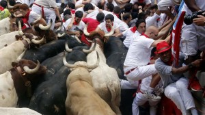 Runners get trapped with Fuente Ymbro fighting bulls during the seventh running of the bulls of the San Fermin festival in Pamplona