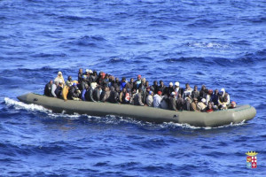 Migrants are seen in a boat during a rescue operation by Italian navy ship San Marco off the coast to the south of the Italian island of Sicily