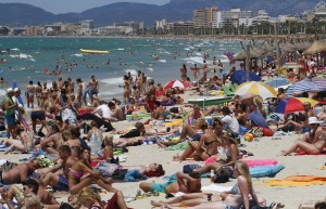 Tourists crowd Palma de Mallorca's Arenal beach on the Spanish Balearic island of Mallorca July 25, 2011. Spain was host to 24.8 million foreign tourists in the first half of 2011, a 7.5% increase over the same period in 2010, according to figures from the Spanish Institute for Tourist Studies. REUTERS/Enrique Calvo (SPAIN - Tags: TRAVEL SOCIETY) - RTR2PA0I