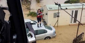 A woman is rescued by the Guardia Civil from her flooded home in Cartama