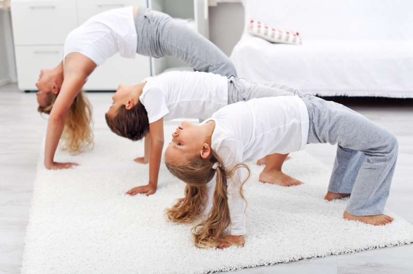 Woman And Kids Doing Bridge Stretch Gymnastic Exercises At Home