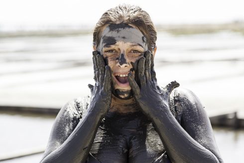 Woman Giving Herself A Mud Bath