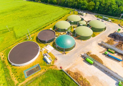 Aerial View Over Biogas Plant And Farm In Green Fields. Renewabl