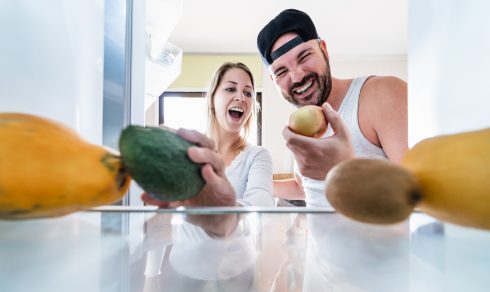 Young Couple Open The Fridge At Home While Choosing Organic Frui