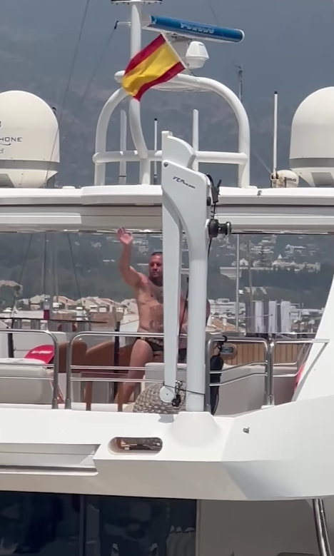 Conor McGregor luce un traje de baño Versace mientras saluda desde detrás de un yate de lujo en Marbella, España.