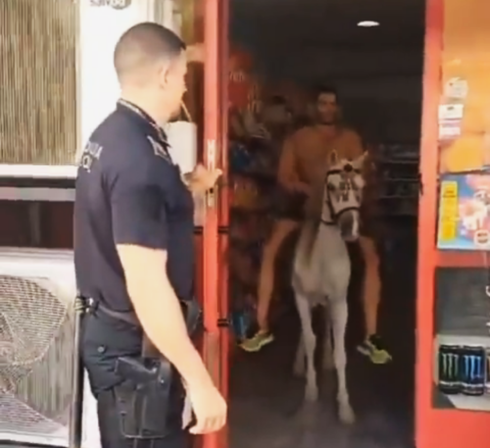 Watch: Bizarre moment a topless man on a horse exits his local corner shop in Spain